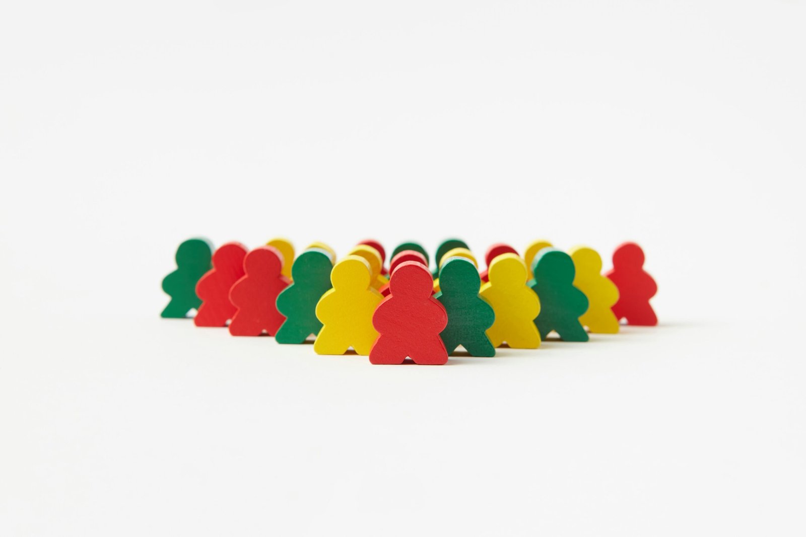Vibrant wooden toy figures arranged in rows against a plain background, emphasizing organization and creativity