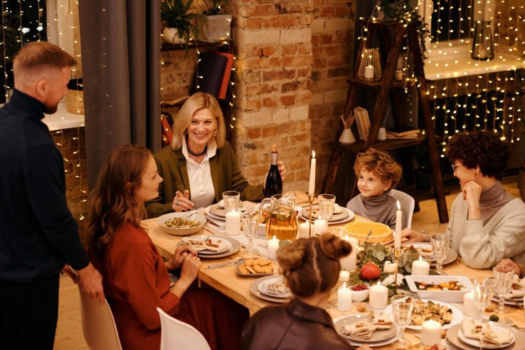 Danish meals - Traditional Danish Food Guide: Famous Meals from Smørrebrød to Flæskesteg - Career Denmark Warm family gathering enjoying Christmas dinner with festive decor and lights.