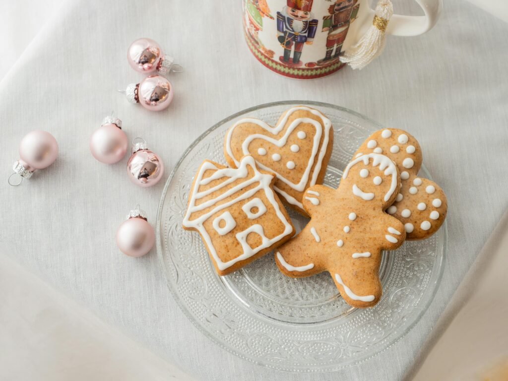 Danish Christmas Traditions - Exploring Danish Christmas Traditions: From Festive Foods to Hygge Celebrations - Career Denmark Delightful gingerbread cookies on a plate with Christmas ornaments, perfect for holiday celebrations