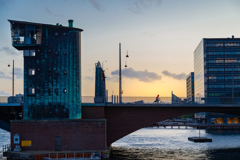 Silhouette of a Person Riding a Bicycle Over the Bridge in Sunset in Copenhagen