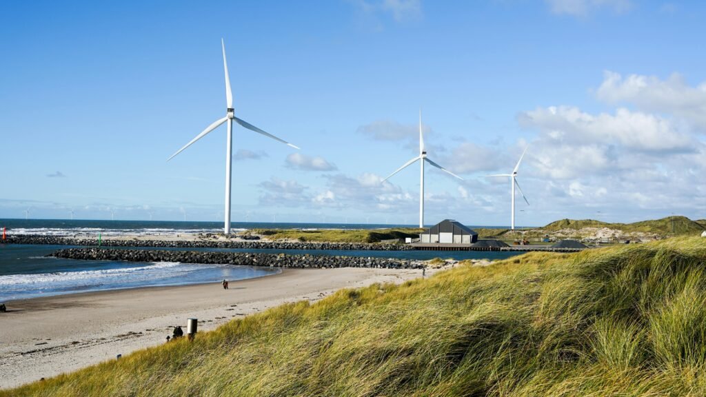 Wind turbines on white sand beach Denmark